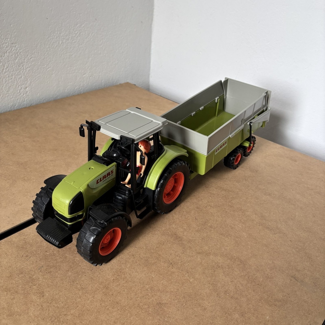 Duży traktor Claas z przyczepą i figurką