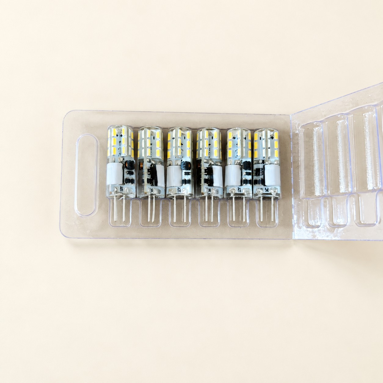 Zestaw sześciu żarówek kapsułkowych — aranżacja poglądowa AI na jasnym tle