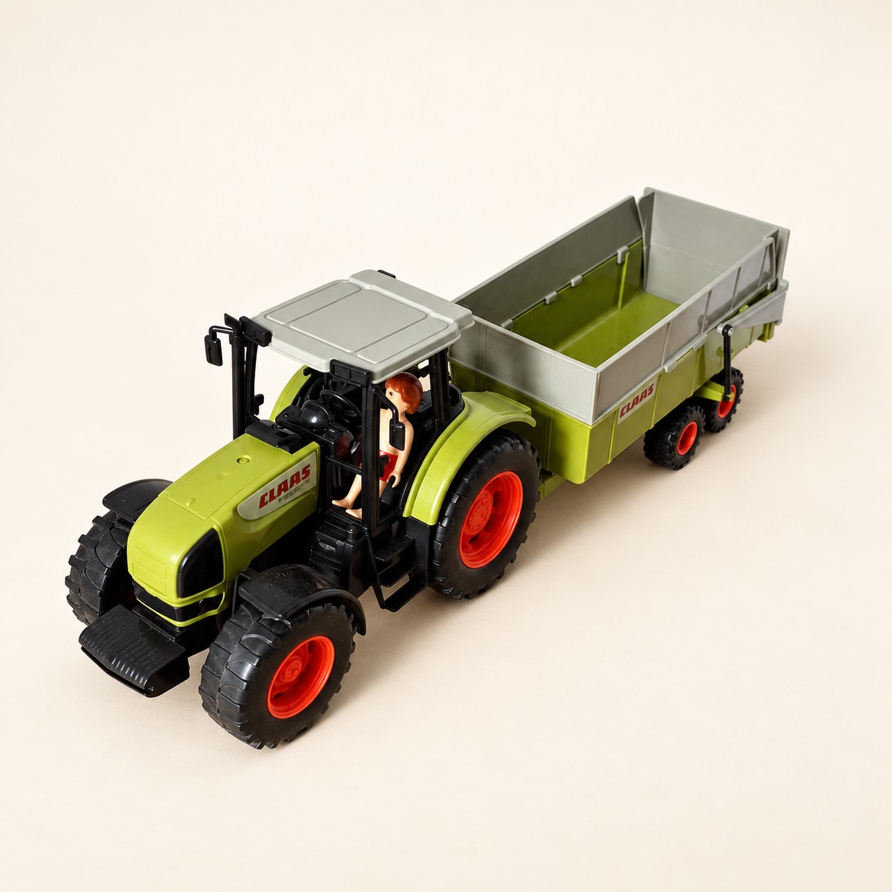 Zielony zabawkowy traktor CLAAS z przyczepą — aranżacja poglądowa AI na jasnym tle