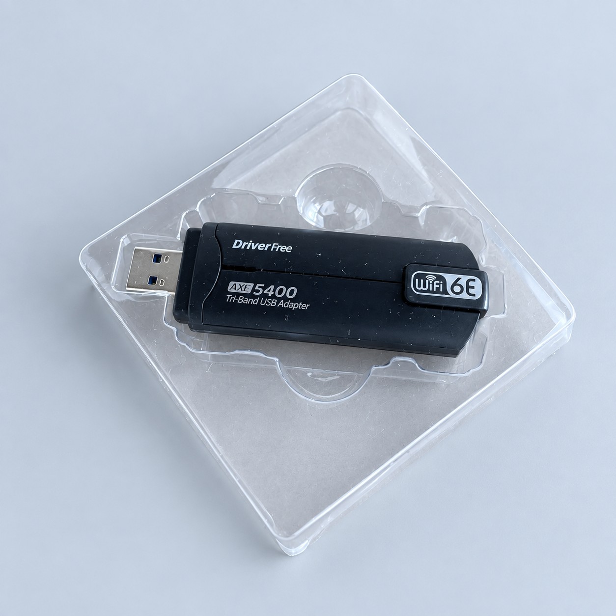 Adapter USB WiFi AXE5400 — aranżacja poglądowa AI na szaroniebieskim tle
