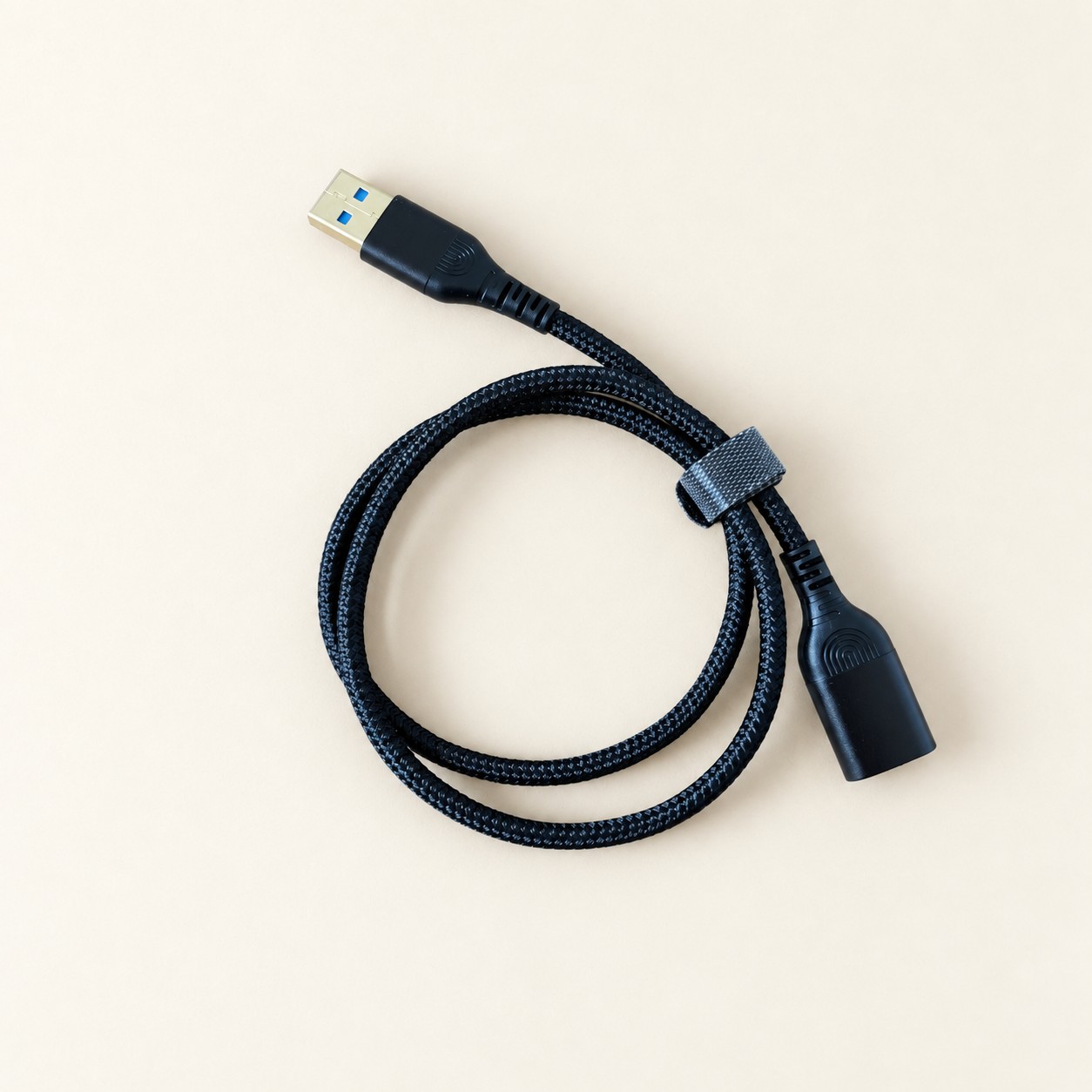 Czarny przedłużacz USB w oplocie — aranżacja poglądowa AI na jasnym tle
