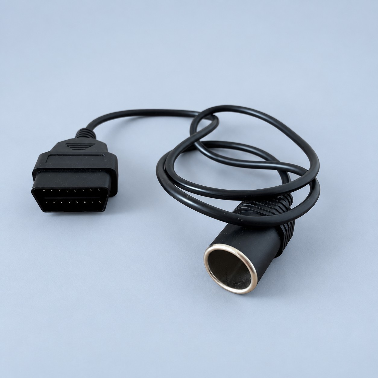 Adapter OBD2 z gniazdem zapalniczki — aranżacja poglądowa AI na szaroniebieskim tle