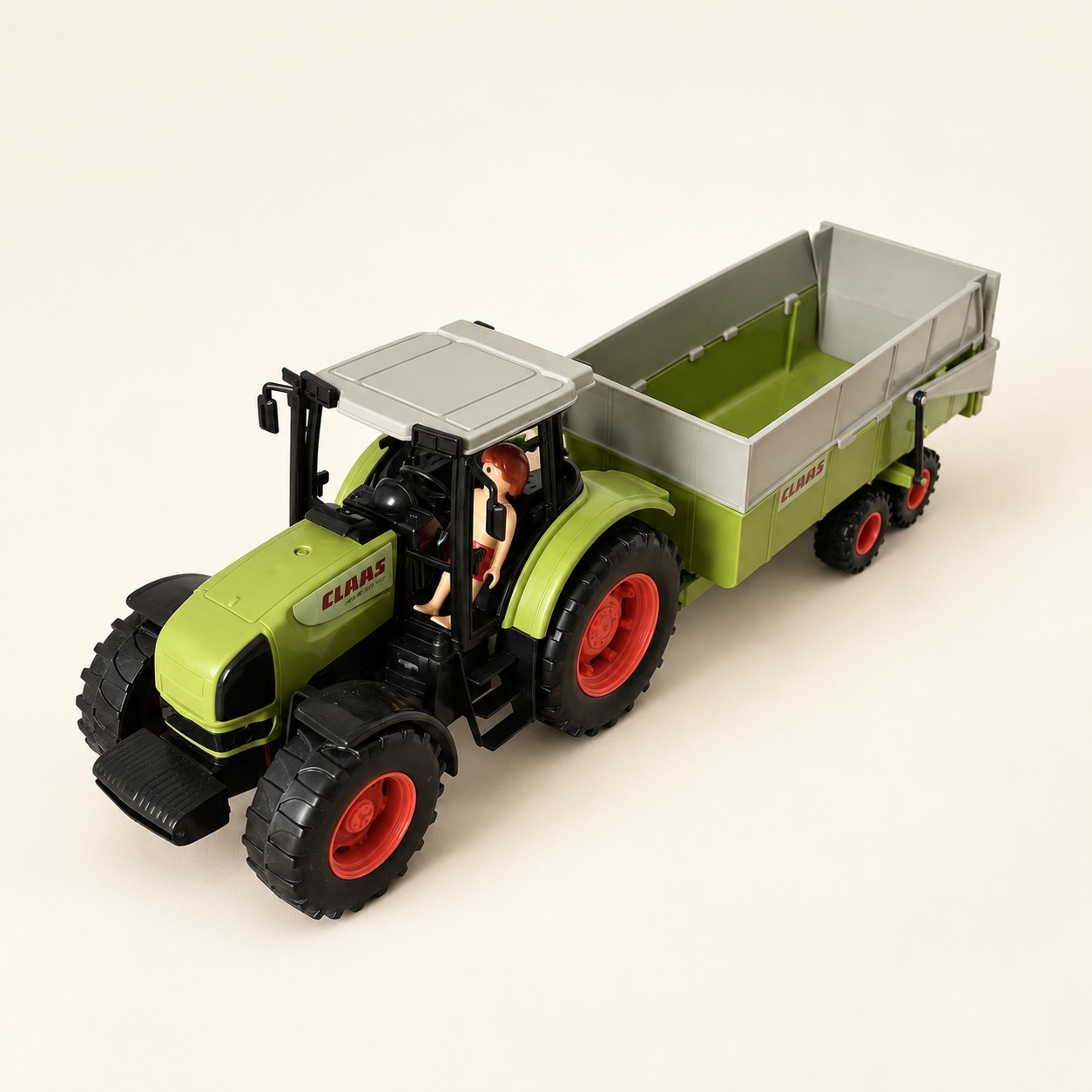 Zielony zabawkowy traktor CLAAS z przyczepą — aranżacja poglądowa AI na jasnym tle