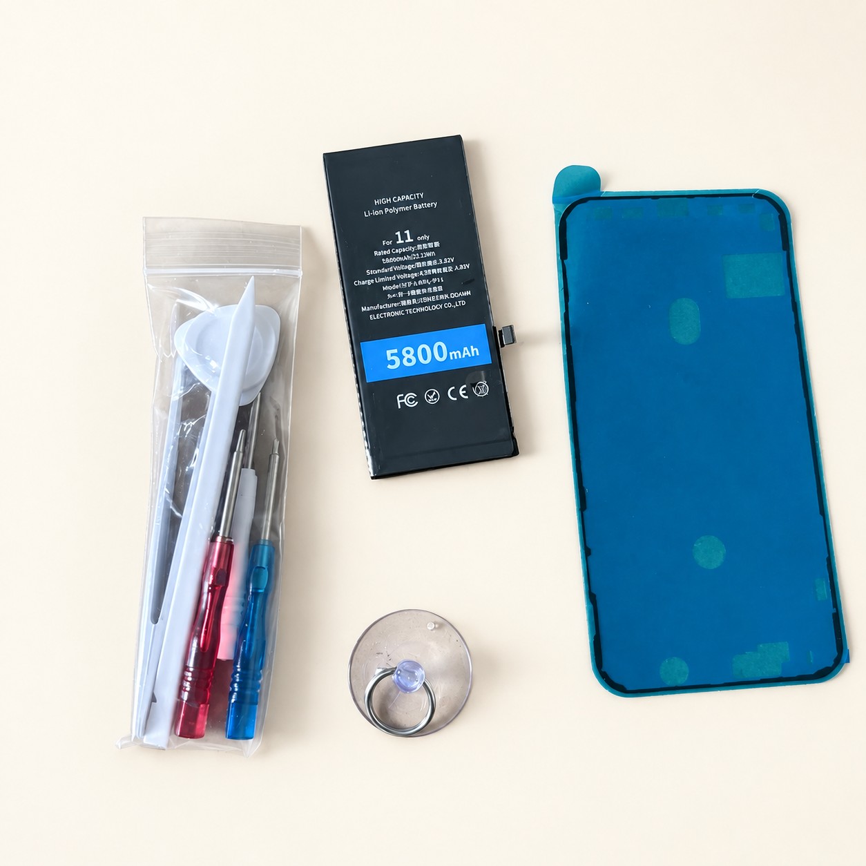 Akumulator do iPhone 11 z narzędziami — aranżacja poglądowa AI na jasnym tle